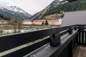 Un balcone con vista su una montagna e un parcheggio.