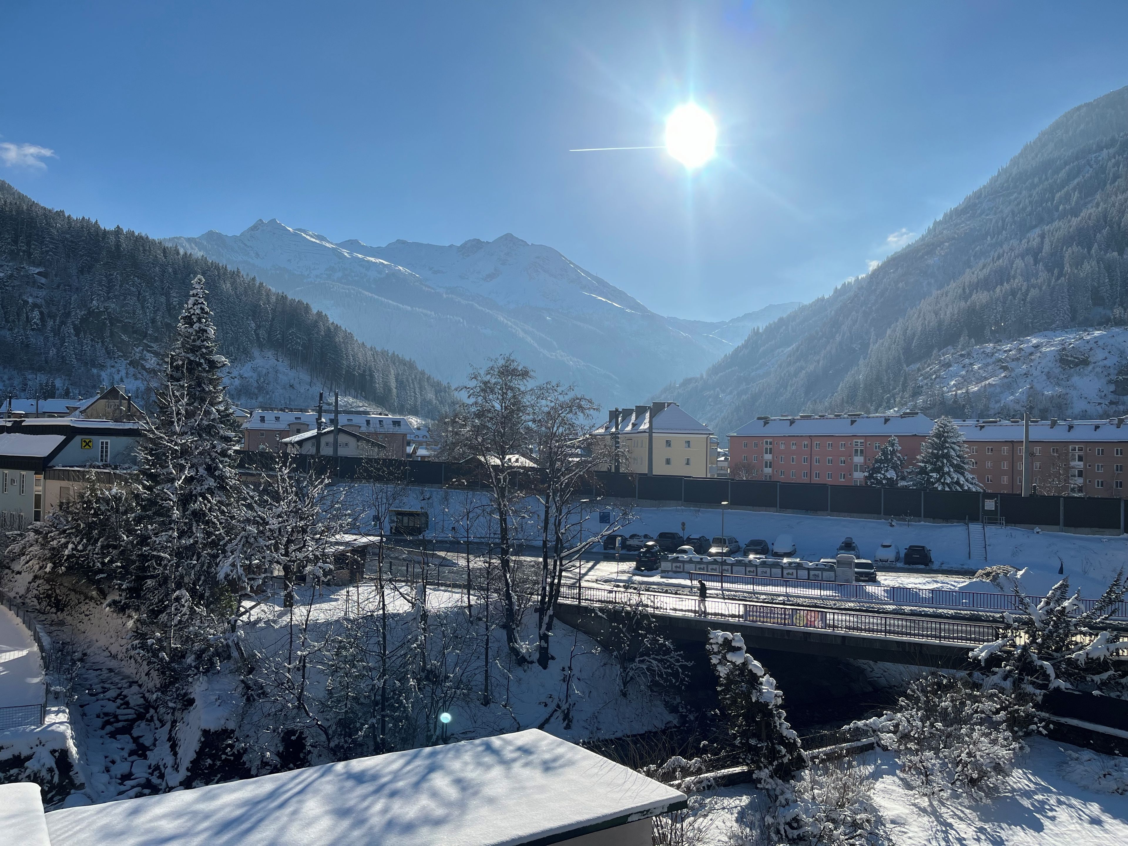 A snow-covered mountain landscape with buildings and a bridge.