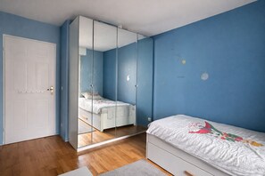 Un dormitorio con cama, armario y puerta.