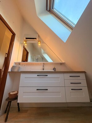 A modern bathroom with a skylight, a large mirror, and a white vanity with drawers. - Normandy farmhouse with a fireplace and a 2,800 m² enclosed garden. Pets welcome (Heudicourt)
