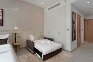 A modern hotel room with a bed, bedside tables, a wardrobe, and a shower area. - Stylish City Stay in Peninsula Four (Dubai)