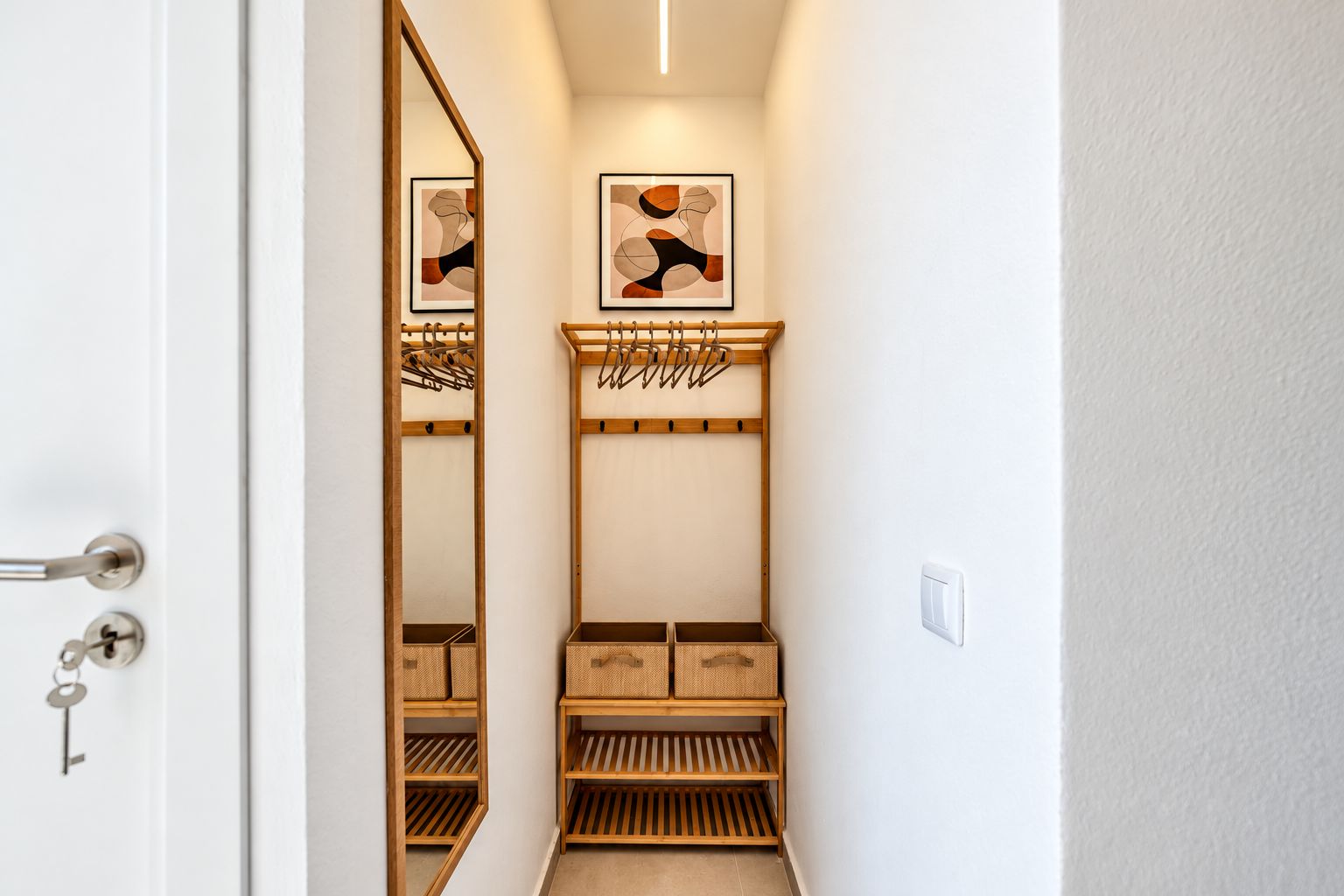 Stylish entryway with full-length mirror, coat rack, and shoe storage