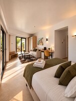 Un dormitorio moderno con una cama grande, un escritorio y una zona de estar.