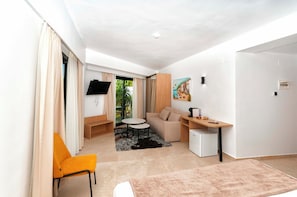 A compact hotel room with a sofa, a small table, a TV, and a painting on the wall. - Barocco Hotel Denia  (Dénia)
