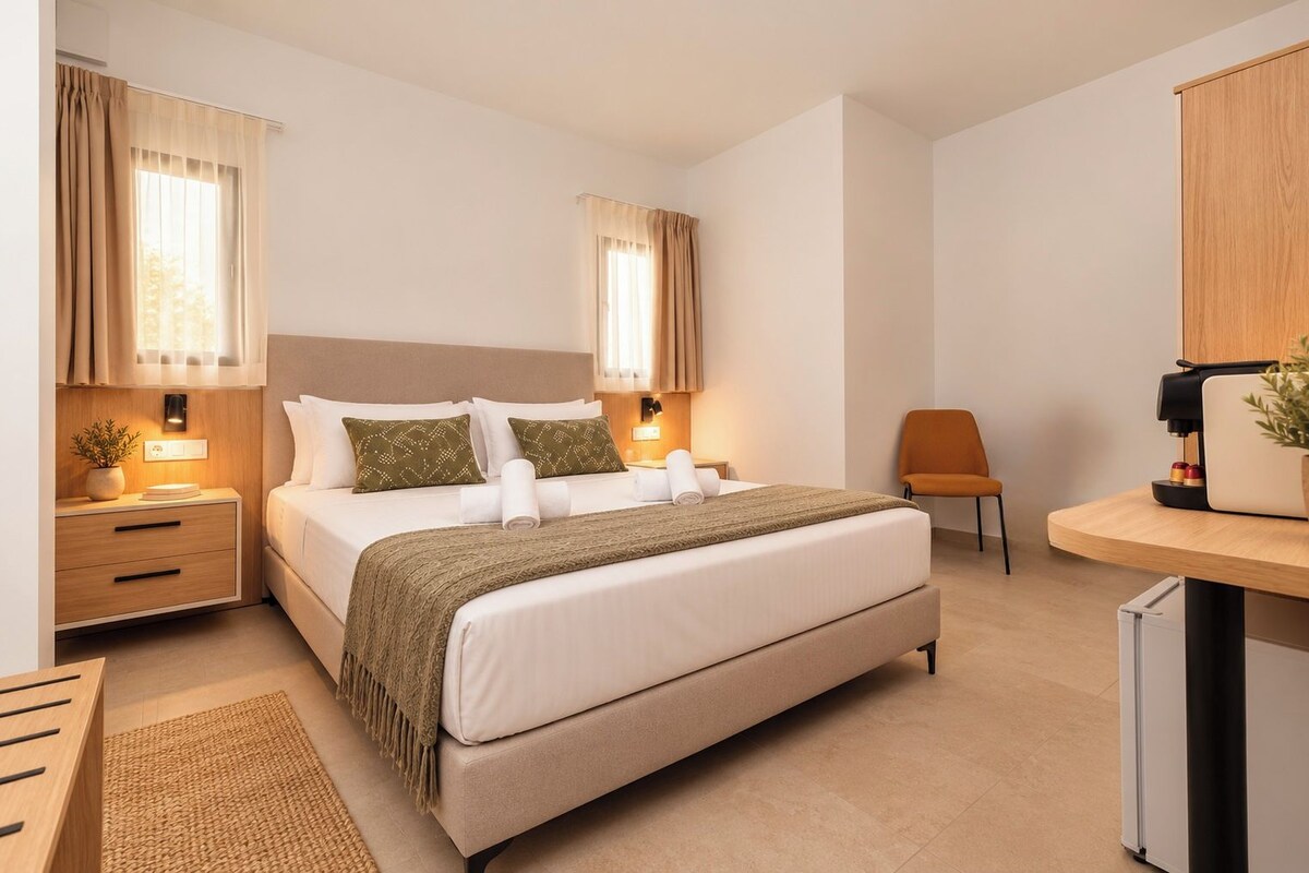 A modern hotel room with a bed, bedside tables, a desk, and a chair.