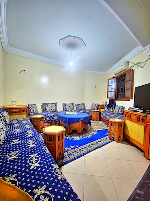 Quarto com sofá, mesa de jantar e televisão.