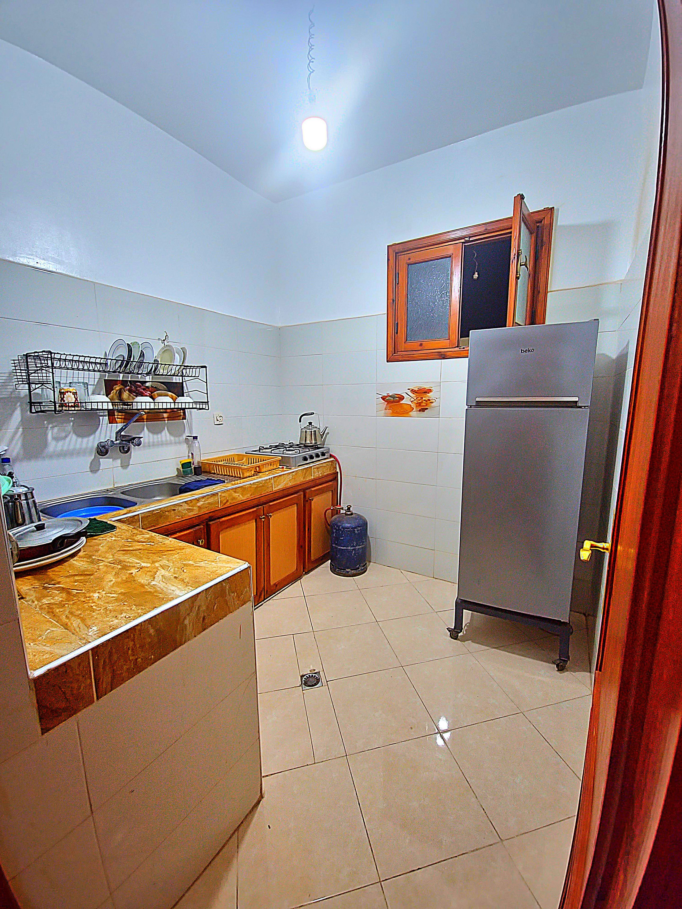 A kitchen with a built-in stove, a sink, and a refrigerator.