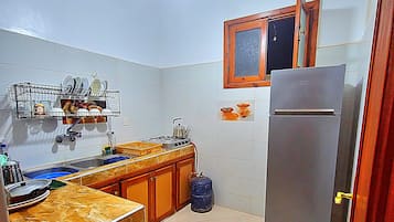 A kitchen with a built-in stove, a sink, and a refrigerator.