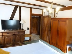 A room with a television on a wooden cabinet, a lamp, a chandelier, and a wardrobe. - Apartment 'Hohlmühle Vogelsberg Hessen' with Absolute Seclusion, Wi-Fi, Private Terrace & Garden (Feldatal)