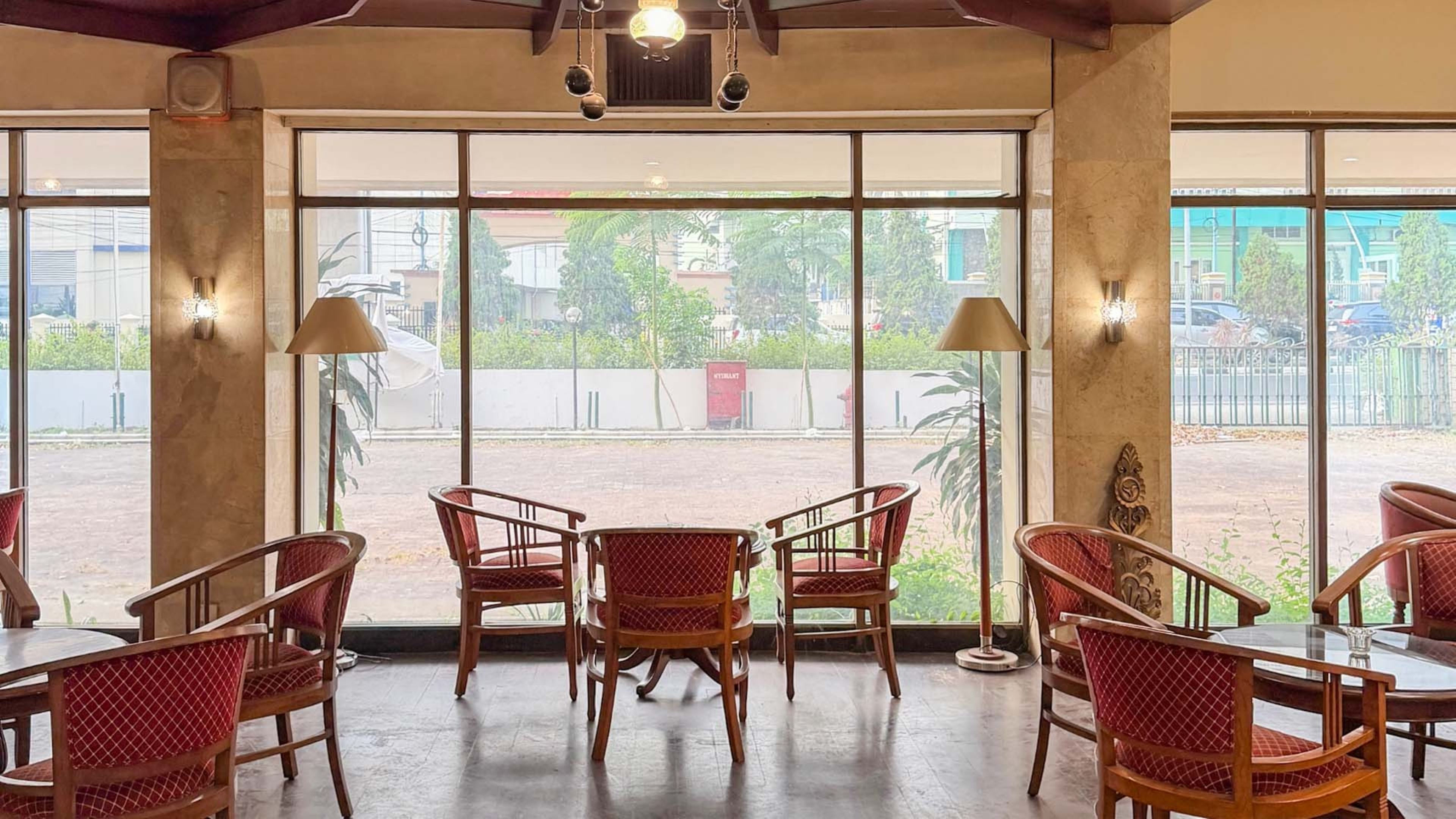 A room with large windows, wicker chairs, and a round table.