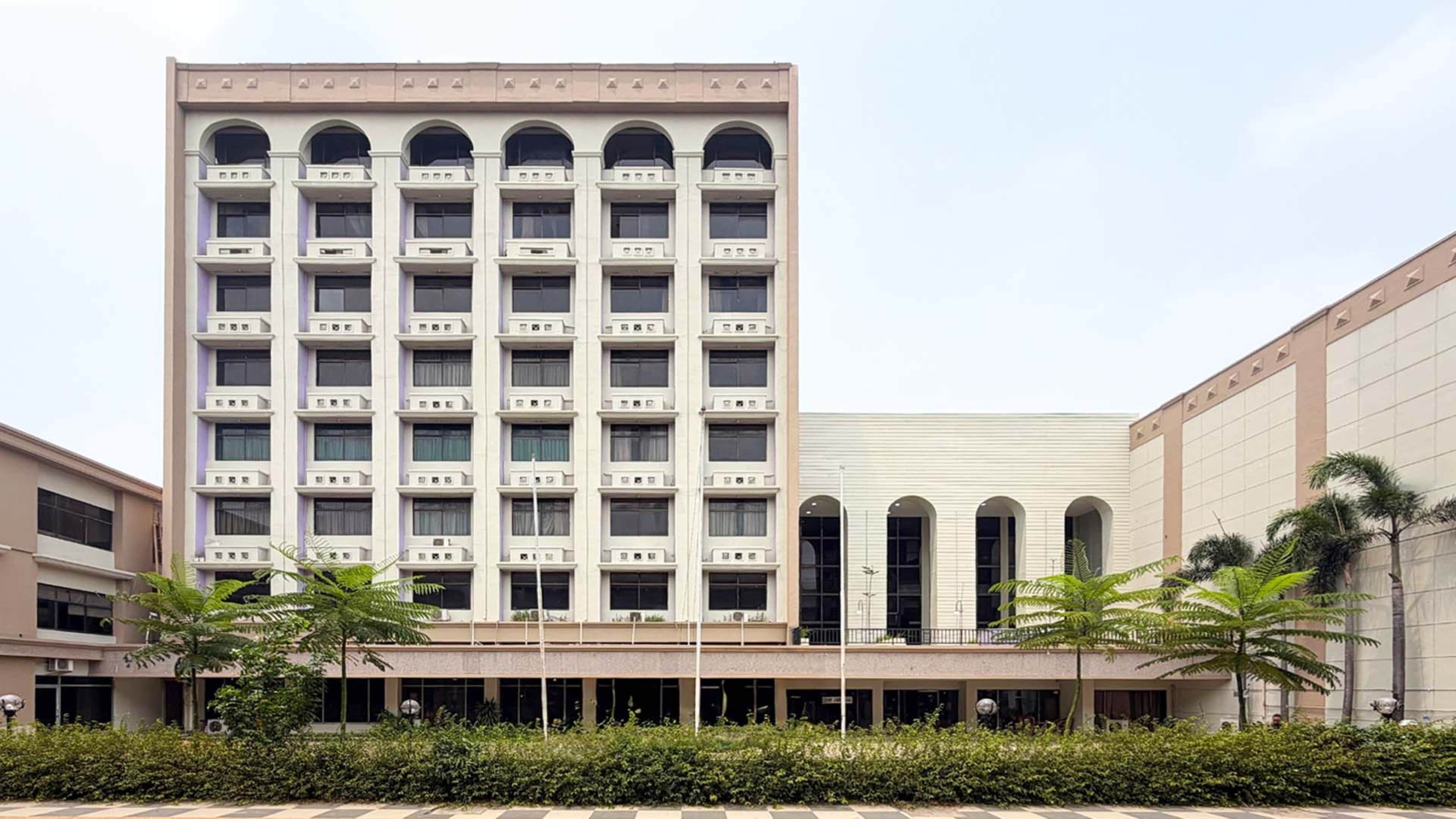 Un immeuble à étages doté d’une façade symétrique, de grandes fenêtres et d’une entrée centrale surmontée d’un auvent.