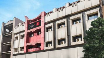 A hotel building with a prominent sign for 'Collection Hotel Prestige' and multiple balconies.
