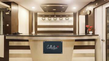 Un comptoir d’accueil avec une pancarte indiquant : « Collection Signature Stays by CHTG ».