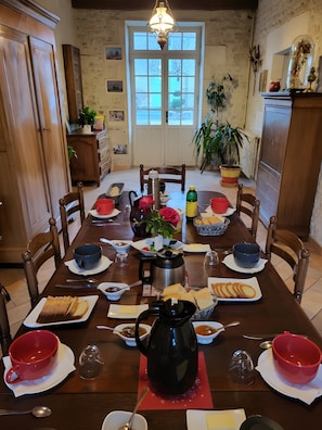 Ein Esstisch, gedeckt mit verschiedenen Gerichten, einer Kaffeekanne und einem Blumentopf.