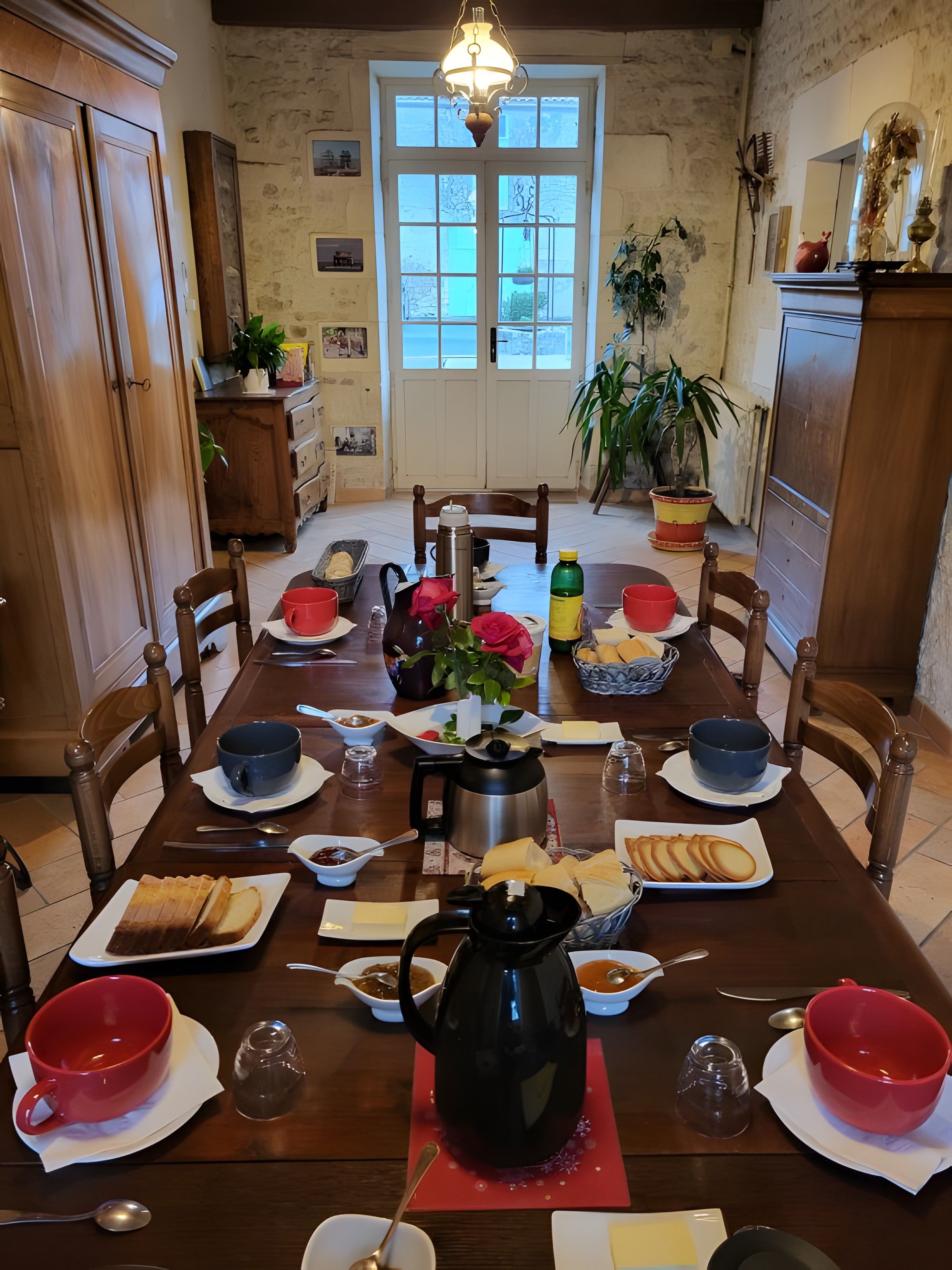 A dining table set with various dishes, a coffee pot, and a potted plant.
