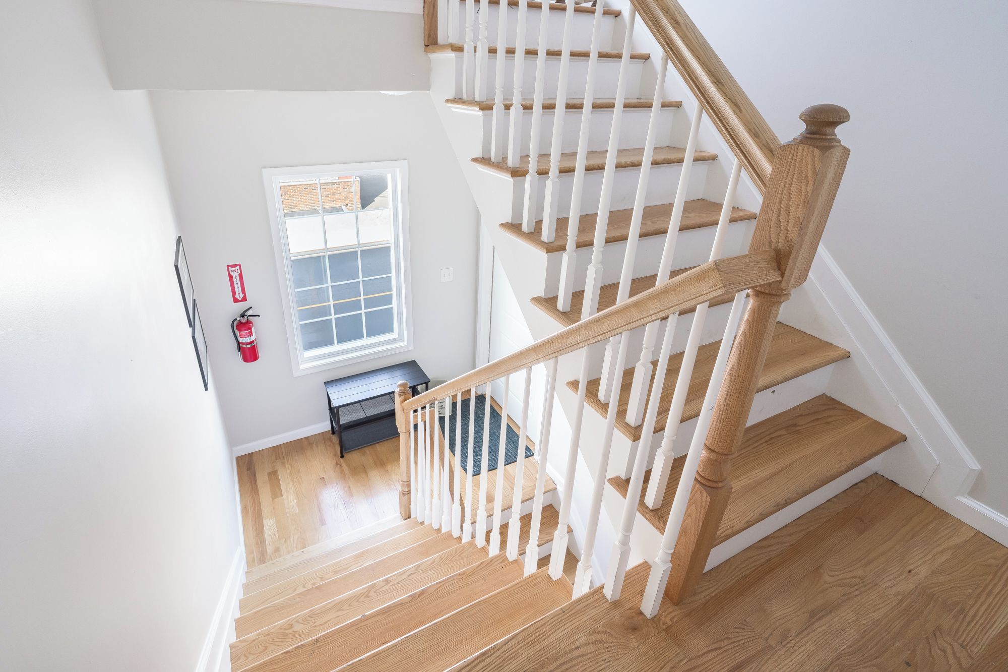 Eine Holztreppe mit weißen Geländern, die zu einer oberen Etage führt.