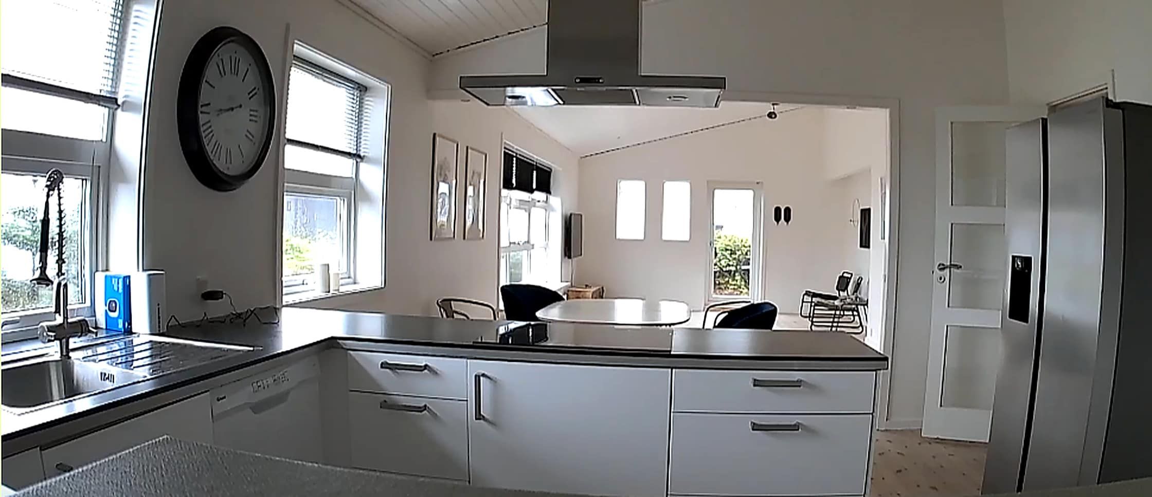 Eine moderne Küche mit weißen Schränken, einer Edelstahl-Arbeitsplatte und einem eingebauten Backofen.