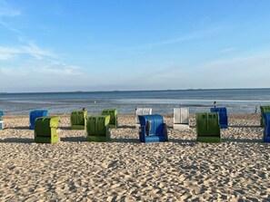 A beach with rows of beach chairs and umbrellas, a clear sky, and calm sea. - Westerhus Nieblum (Nieblum)
