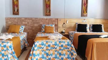 Habitación de hotel con dos camas, una pared de ladrillo decorativa y un cabecero de madera.