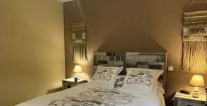 A bedroom with a bed, two bedside tables, a wall-mounted lamp, and a decorative wall hanging. - Holiday Home 'Cozy House with Outdoor Area' with Mountain View, Private Terrace and Wi-Fi (Anduze)