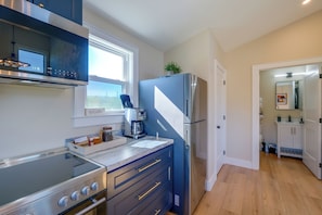 Eine moderne Küche mit Einbauofen, Kaffeemaschine und Kühlschrank.