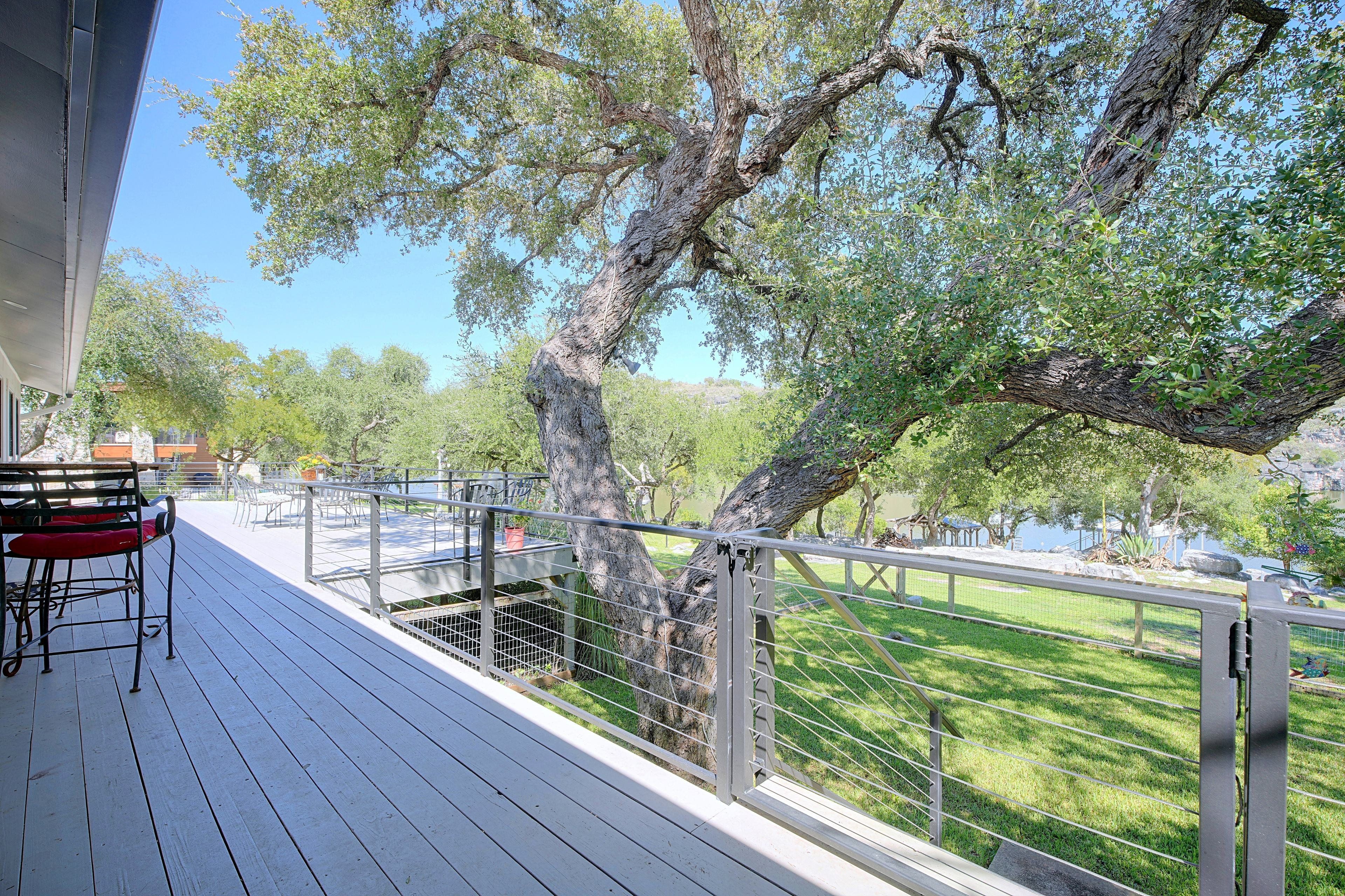 Une terrasse avec des sièges extérieurs et une vue sur un espace verdoyant arboré.