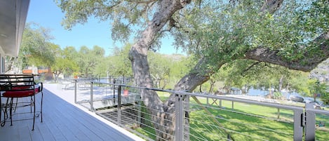 Une terrasse avec des sièges extérieurs et une vue sur un espace verdoyant arboré.