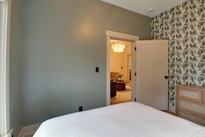 A bedroom with a bed, a door, and a wall with a tree pattern. - Walk to Old Town Eats, Shops! Modern Home w/ Yard (Sherwood)