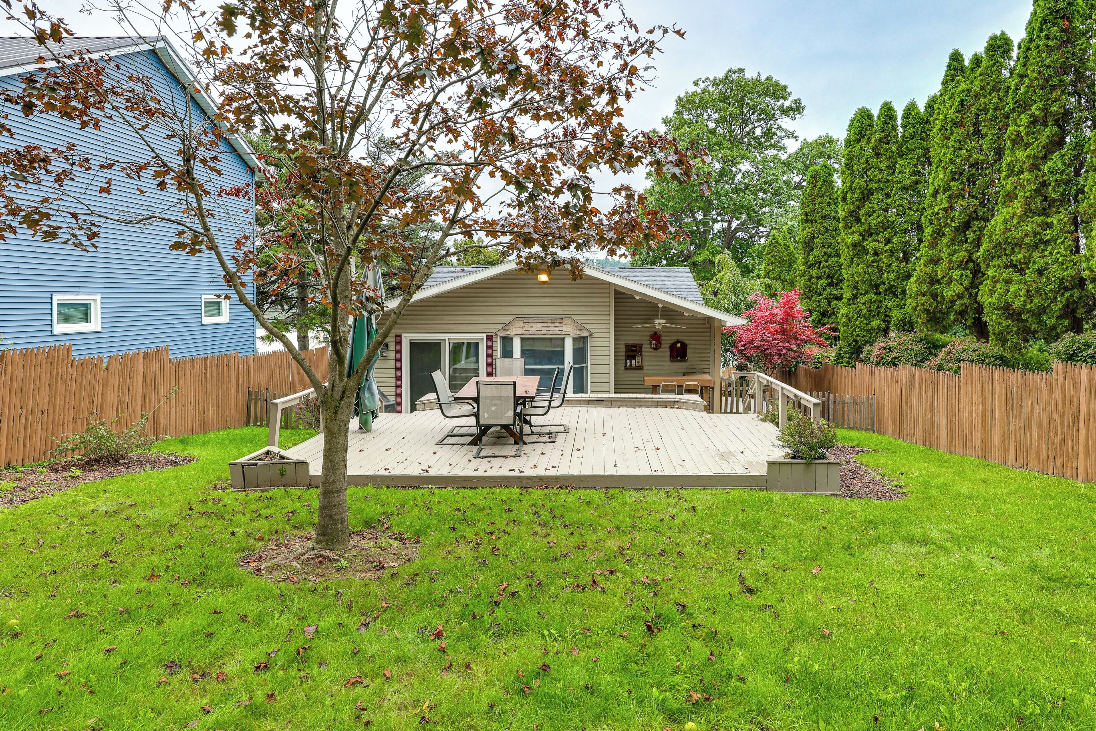 A backyard with a patio, a dining table, and a covered seating area.