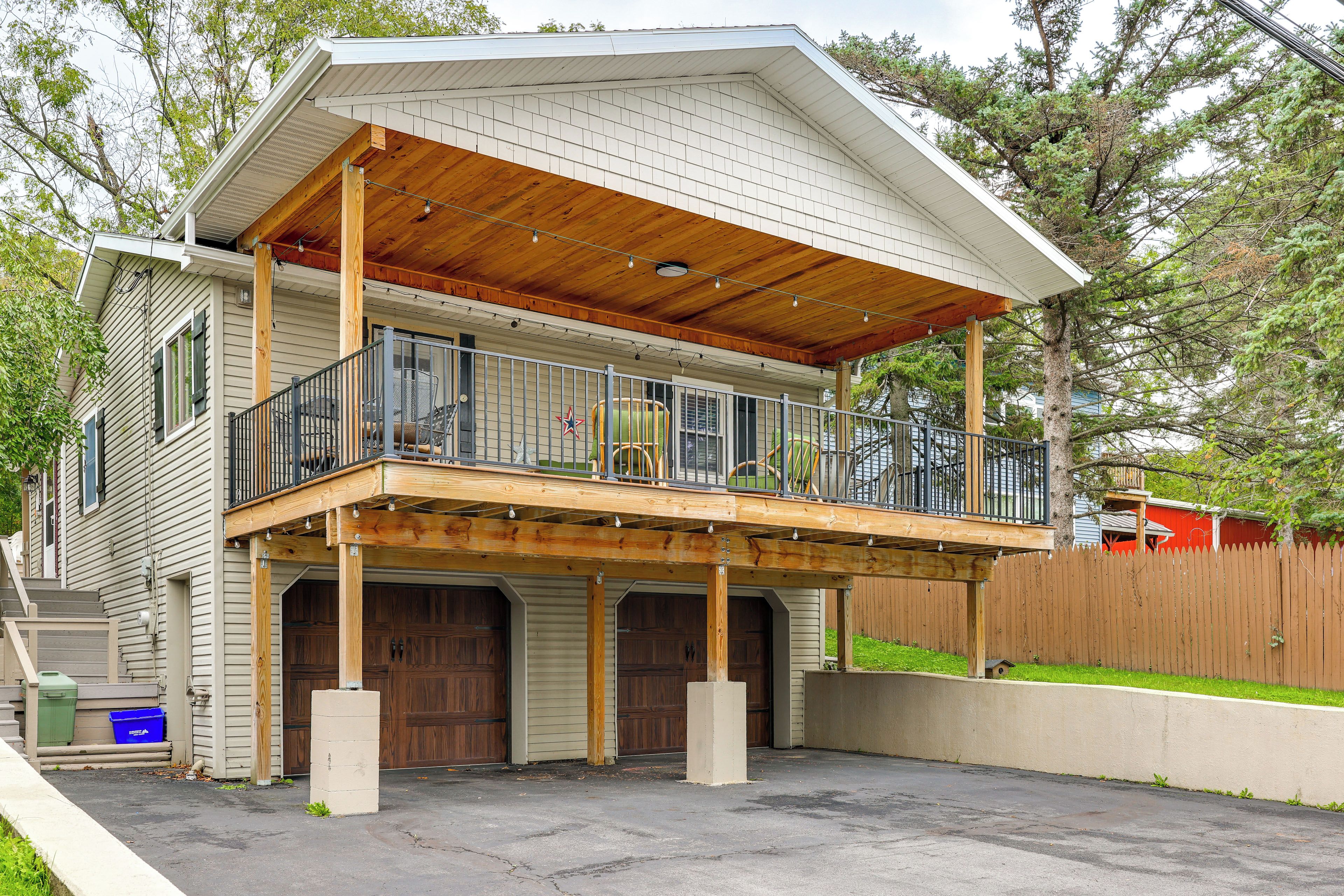 A two-story house with a covered porch and a fenced backyard.