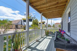 A covered porch with a railing, potted plants, and a view of the neighborhood. - New Veteran Host Luxe Book Now for Wow (Galveston)