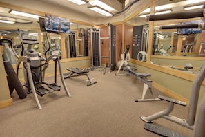 A gym with cardio machines, weight training equipment, and mirrors. - Mountain View | King Bed | Hot Tub (Keystone)