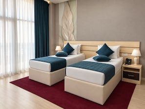 Habitación de hotel con dos camas, una alfombra roja, cabecero de madera y una pared con diseño de hojas.