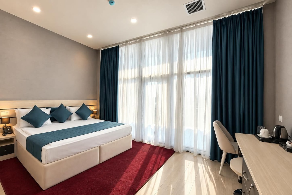 Una habitación de hotel con una cama, un escritorio y una silla.