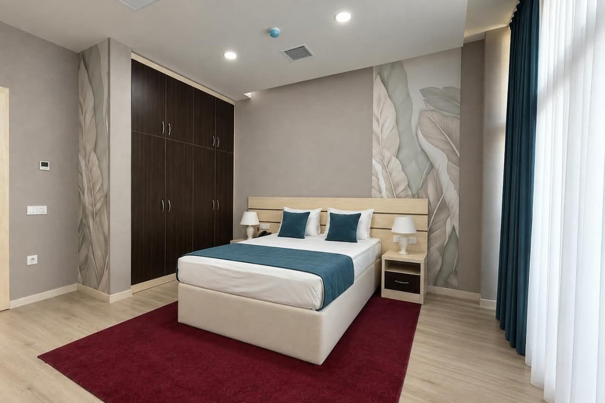 Un dormitorio moderno con una cama grande, un armario y una mesita de noche.
