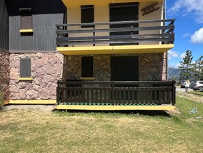 Ein zweistöckiges Gebäude mit einer Stein-Fassade, einem Balkon mit Holzgeländer und freiem Blick auf die umliegende Landschaft.
