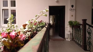 A corridor with a railing, potted plants, and a sign for GRAN hostel. - GRAN hostel (Banska Bystrica)