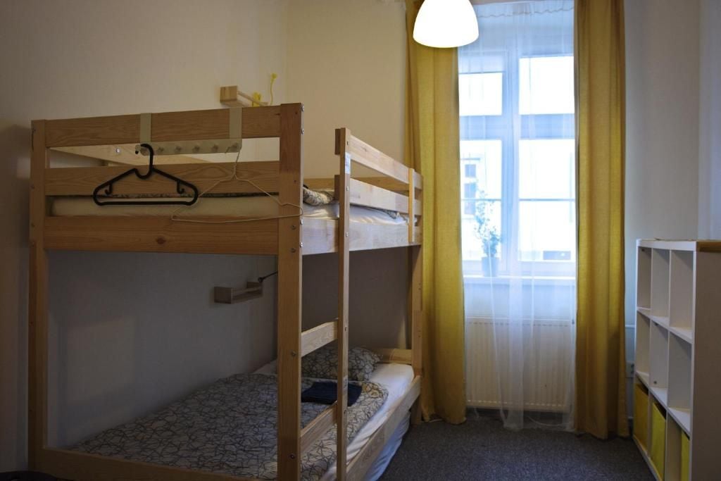 A bunk bed room with a window, a hanging light fixture, and a radiator.