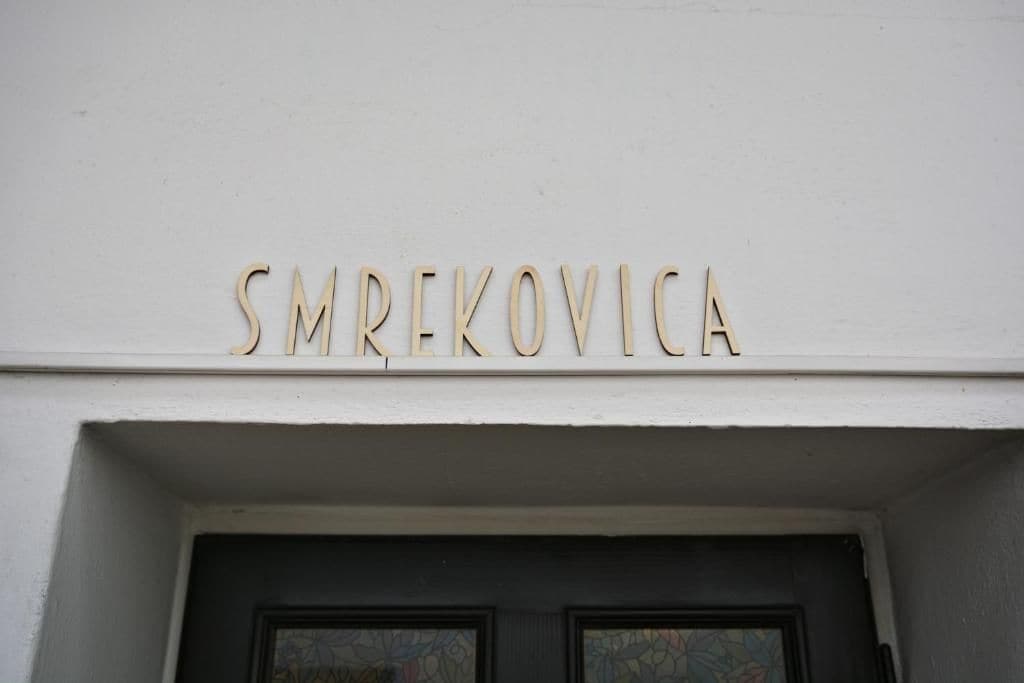 La entrada de un edificio con el nombre 'SMREKOVICA' en letras mayúsculas.