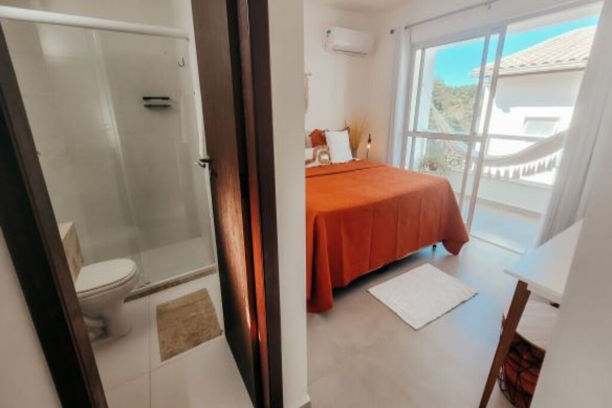 A bathroom with a glass shower enclosure and a toilet.