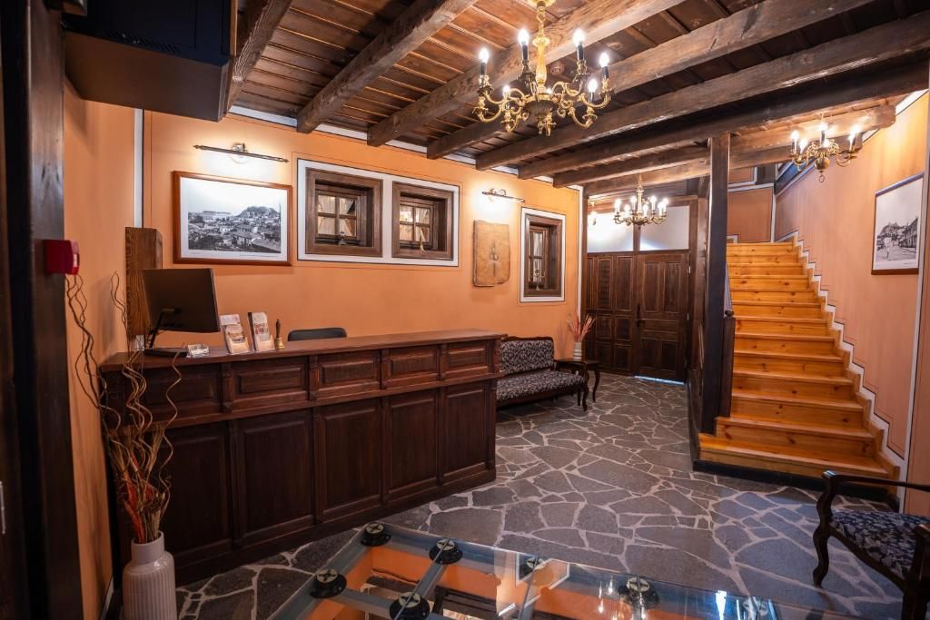 Un vestíbulo con mostrador de recepción, una escalera y cuadros enmarcados en las paredes.