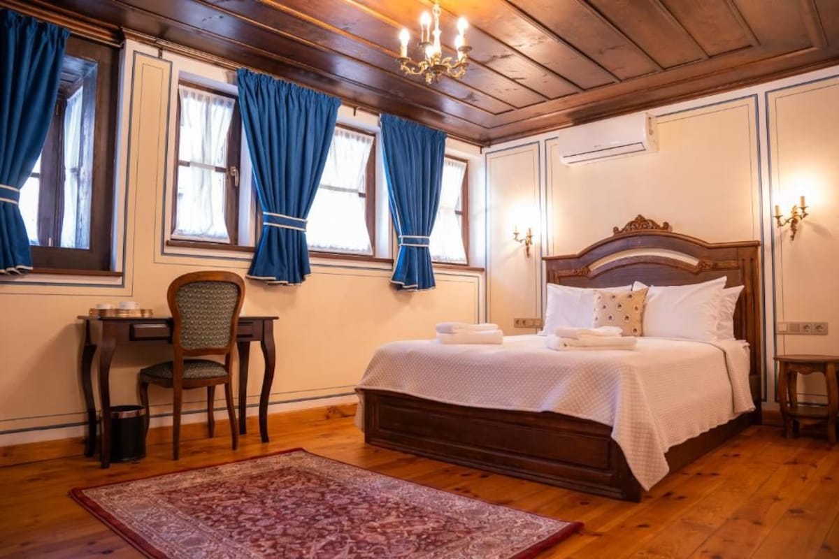 Un dormitorio con una cama de madera, un escritorio y una silla.