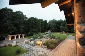 A landscaped garden with a paved pathway, a stone archway, and a well-lit outdoor area. - A NEW MANOR for families & friends (up to 20 people), surrounded by nature (Vėžionys)