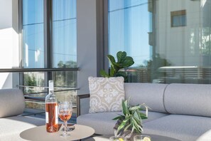 A modern room with a sofa, a round table, a bottle of wine, and a glass. - Urban Living Home | Cozy Retreat (Agios Onoufrios)