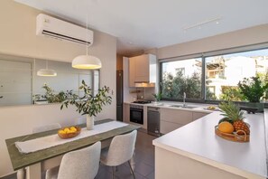 Een moderne keuken met een eethoek, grote ramen en uitzicht.