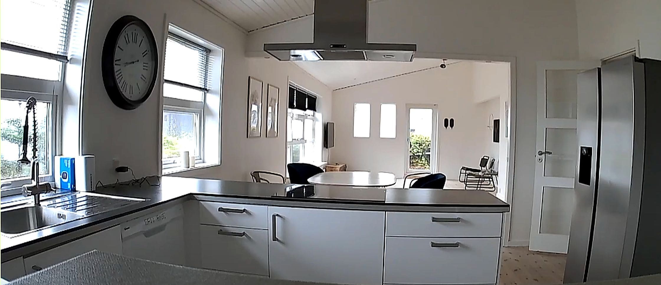 A kitchen with a central island, a built-in oven, and a stainless steel refrigerator.