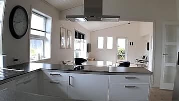 A kitchen with a central island, a built-in oven, and a stainless steel refrigerator.