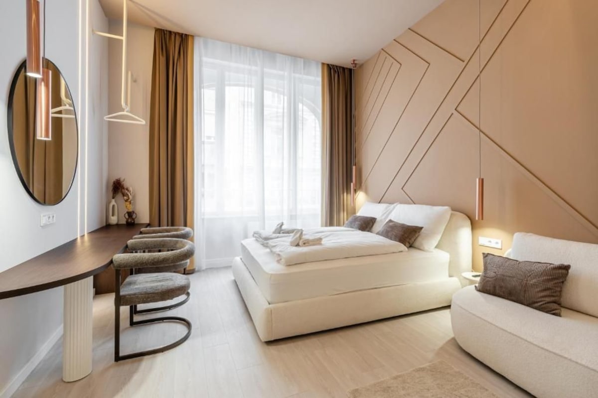 Ein modernes Schlafzimmer mit Bett, Sofa, Schreibtisch und Stuhl.