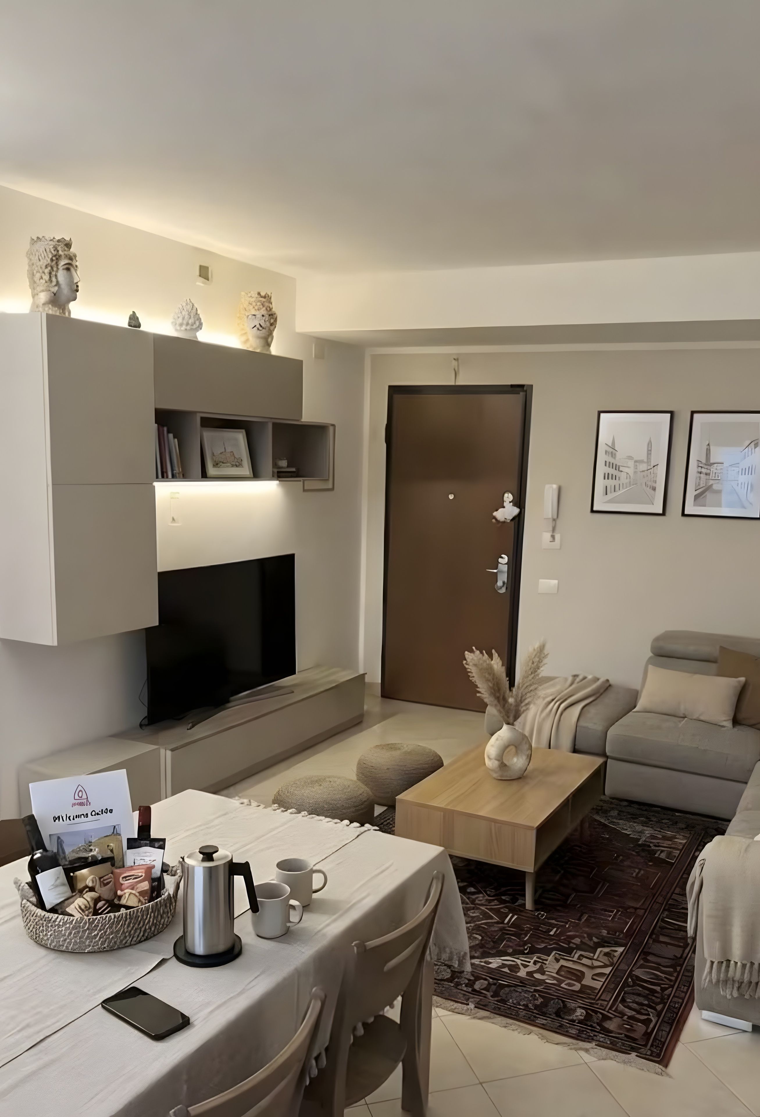 Un salon moderne avec un canapé, une table basse et un coin repas avec une table mise pour deux personnes.