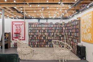 A cozy reading area with bookshelves, a swing chair, and a poster. - Lakeview Retreat | Theater, Games & 140 Acres (Monticello)